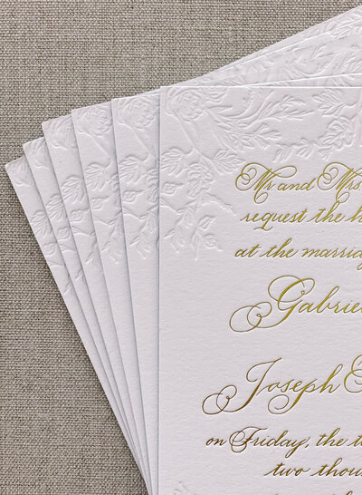 Wedding invitation card with blind deboss and gold foil letterpress printing.