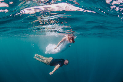 bride and groom swimming underwater