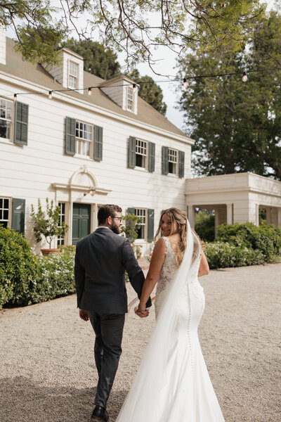 Bride and Groom walking in front of Mccormick Ranch Wedding Venue