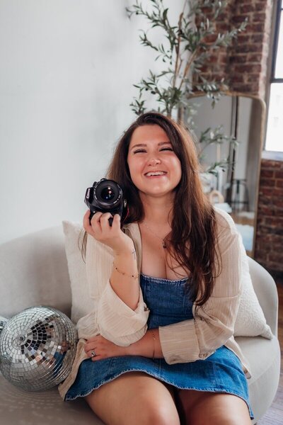 Kemotion brand designer using a camera, focused on website design tips for service-based businesses.