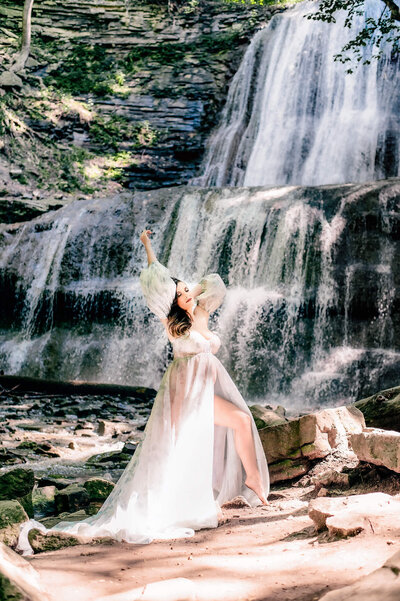 Maternity session of pregnant mom in Greater Toronto water falls in a white gown.