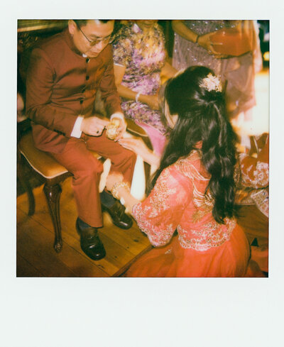 Polaroid photo of a bride holding a colorful spring bouquet, framed in close with soft film tones — a quiet wedding detail captured by a film wedding photographer.