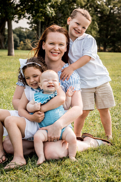 mom hugging with her 3 children at their ct family photo session at waveny park, new canaan ct