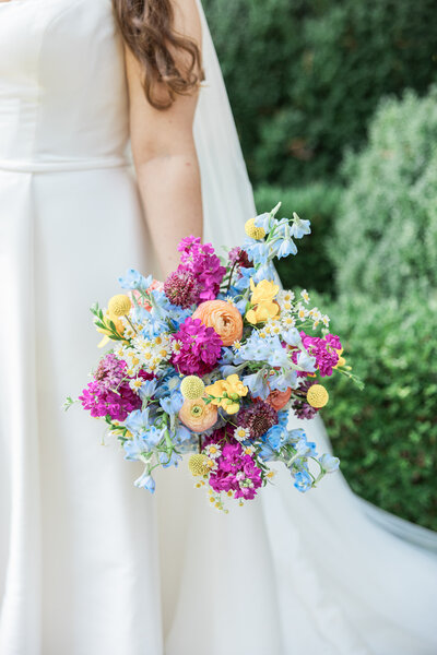 A close up view of someone holding a colorful bouquet of flowers