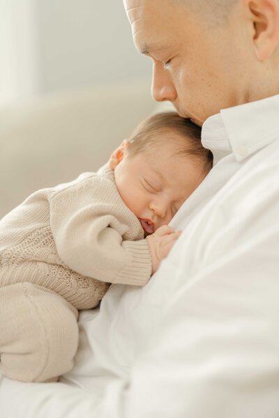dad kissing baby during lifestyle newborn photography in Centreville, VA