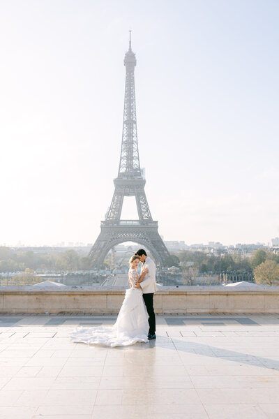 Bride and groom pose in front of the Eiffel Tower in Paris, France