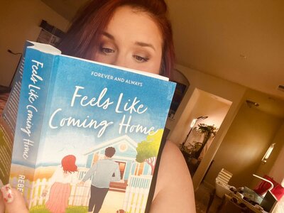 Reader holding copy of Feels like Coming Home by Rebecca Wrights