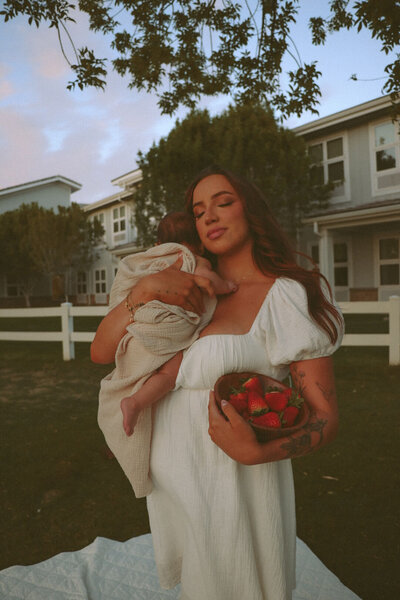 Authentic motherhood photography in a sun-drenched field near Mesa, Arizona.