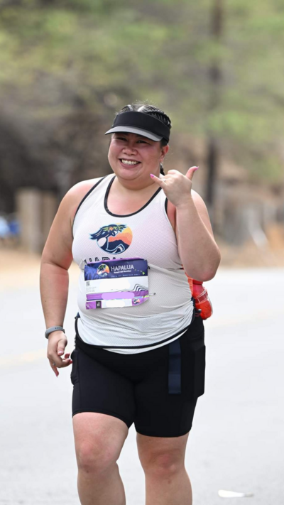 Woman smiling during outdoor run, representing a return to running stronger and without injury after life changes