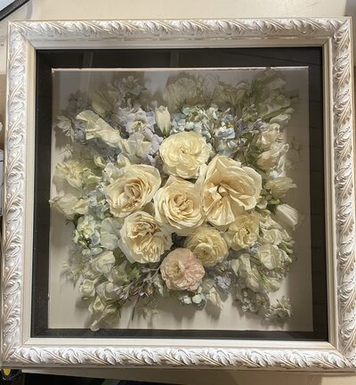 Custom floral preservation design showcasing a wedding bouquet preserved in a shadow box by Leigh Florist