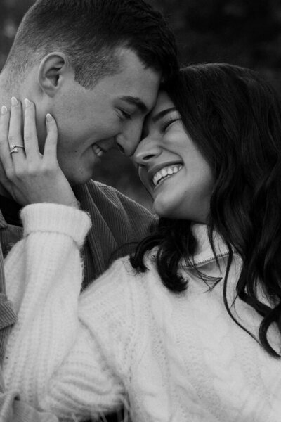 A black and white photo of a couple getting close during their engagement session