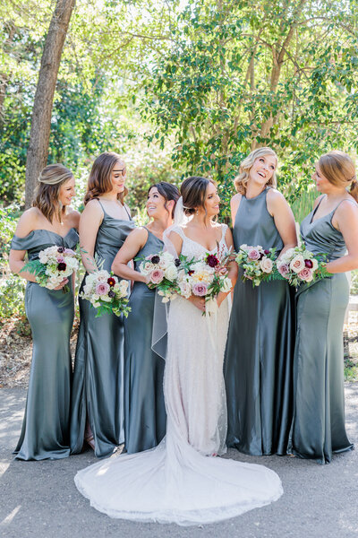 bride posing with her bridesmaids wearing blue dresses