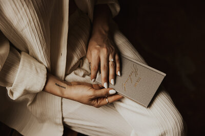 woman sitting down holding a book in her hands