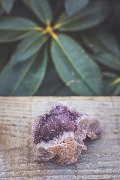 A purple sparkly amethyst pseudomorph crystal sitting.