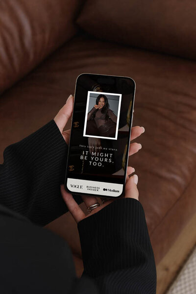 Hand holding a smartphone displaying a Showit website for a business coach—showcasing mobile-optimized design from The Closers Society's Website in a Day service for high-end entrepreneurs.