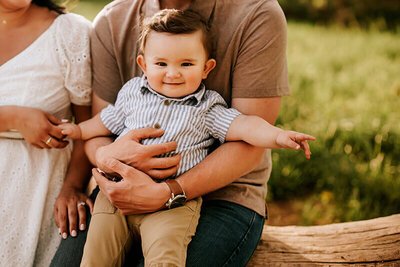 Infant boy smiling while dad holds him