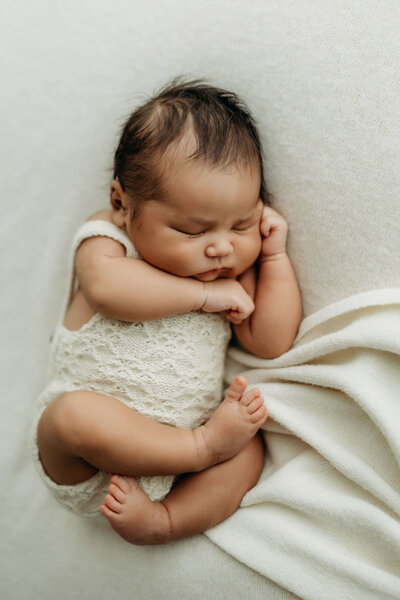  newborn baby sleeps on a bed of cozy blankets for her newborn photo session with Vancouver Washington Photographer