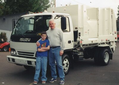 Photo of Steve and Buck Pelroy, when Steve was a child, in front of an Ecosystems garbage truck.