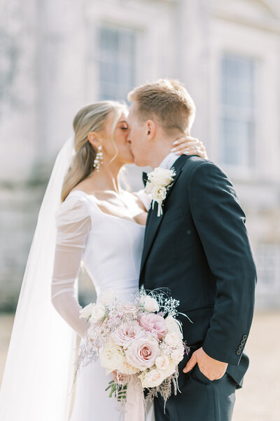 Couple sharing a kiss outside wedding venue