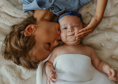 Brother squishing newborn sisters face in Chicago, IL