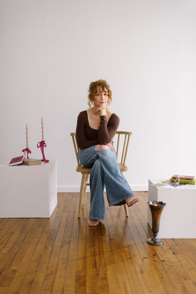 woman with curly hair seated in a chair