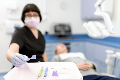 Dentist using dental tools with patient