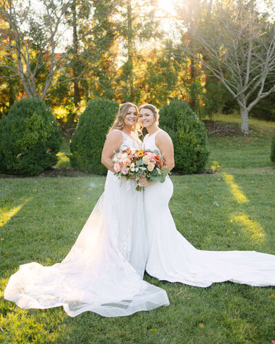 Couple is posing after their wedding ceremony surrounded by trees and lush gardens.