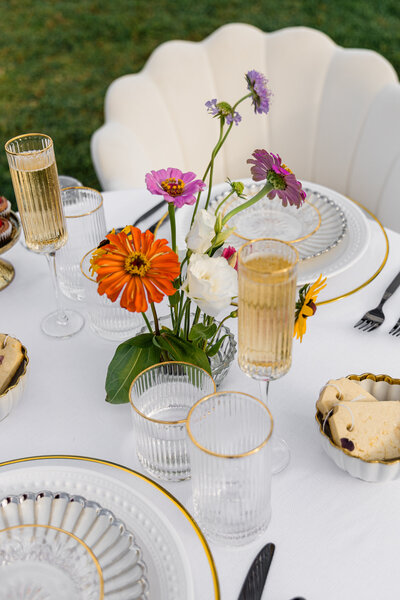 elopement table with mixed metals, orange flowers, pink flowers and champagne