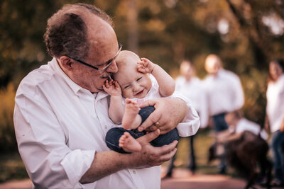 A tender moment between a grandfather and his baby grandson captured outdoors in Champaign, IL. Light By Zoey Photography offers family photography with a focus on multi-generational connections in the Champaign-Urbana area.