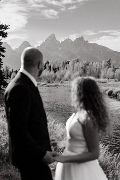 photo of bride and groom looking at mountains in the distance taken by Jackson Hole destination wedding photographer