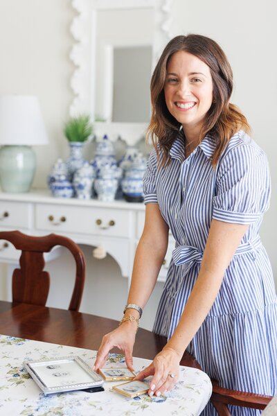 Woman in a striped dress posing in a bright, styled room.