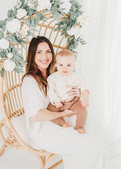 Carlsbad photographer Tristan Quigley highlights a mom and her son on a chair with flowers during their photo session