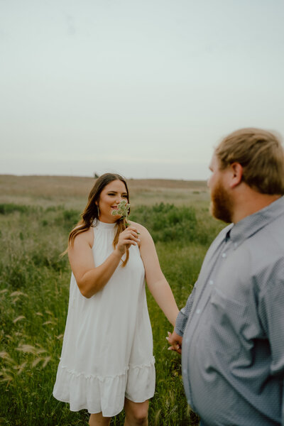bride smells flower that groom picked