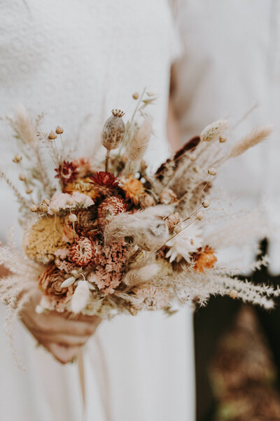 Close-up van een bruidsboeket met droogbloemen.