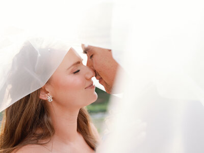 bride and groom kissing under veil
