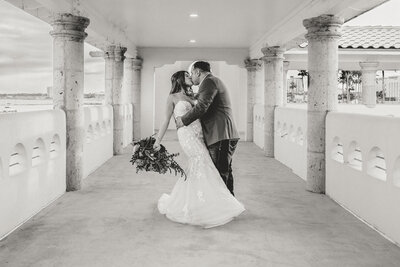 Groom dips bride for a kiss after their wedding at the Art Center of Corpus Christi.