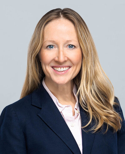 Headshot of Kimberly Koslow, a woman with blonde hair and blue eyes wearing a blue suit jacket and white button up shirt