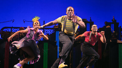 cast of performers mid dance on stage