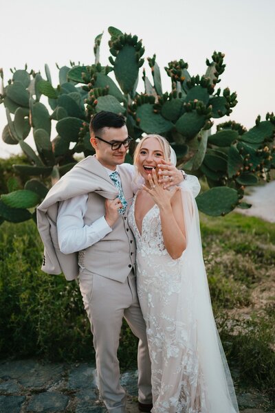 Sunrise elopement at Be Agafay Morocco. Megan holding James' face with sun shining in between their faces.