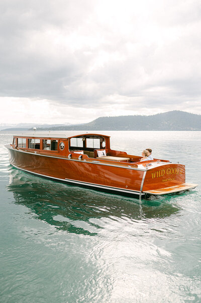 Couple rides on Lake Tahoe boat charter during their engagement photos.