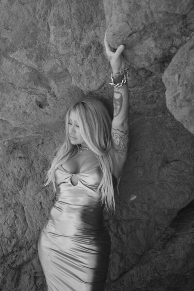 Nicky Lynn on the beach in a gold dress at sunset, embodying transformation and inner confidence