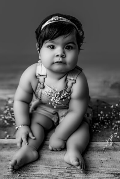 Close up black and white photo of baby girl being held in her dads hand