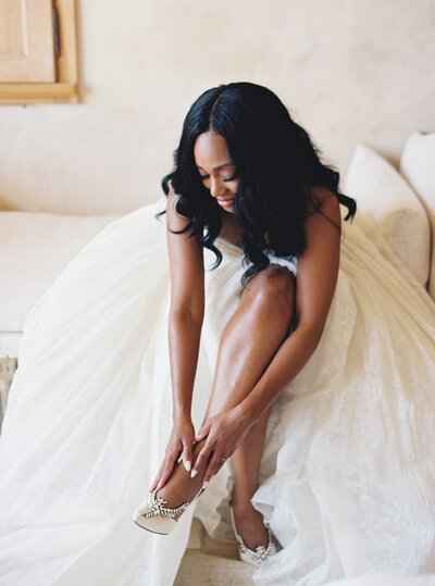 beautiful bride putting on her wedding shoes