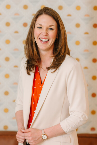 Lindsay smiling wearing a white blazer