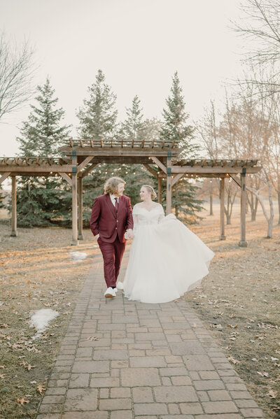 Elopement groom and bride held hands and walk toward to the camera