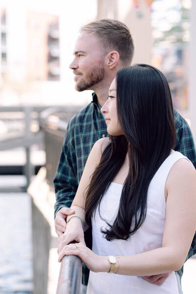 Cinematic wide shot of the couple embracing on the summit, with soft focus and natural light.
