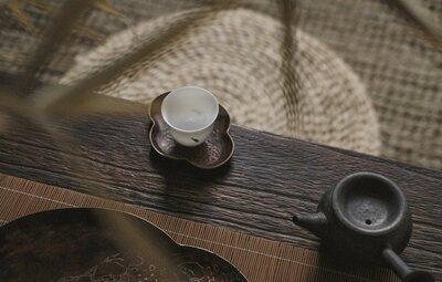 White teacup sits on intricate saucer atop wooden table