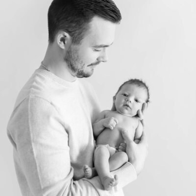 light and airy black and white of new dad with baby son