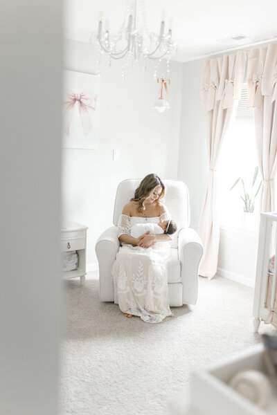 mom looking at newborn baby in nursery taken by nj newborn photographer