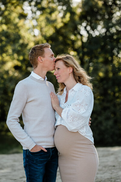 Een intieme zwangerschapsfotoshoot binnenshuis, waarbij een moeder trots haar groeiende buik toont, vastgelegd door Monica Stout Fotografie.